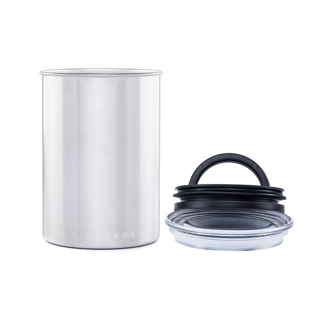 Silver canister with black lid on a white background