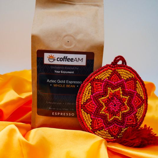 Coffee AM bag of Aztec Gold Espresso with a colorful beaded pouch on an orange fabric background