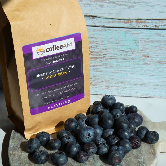 Bag of coffee labeled 'coffee AM' with blueberries on a wooden surface