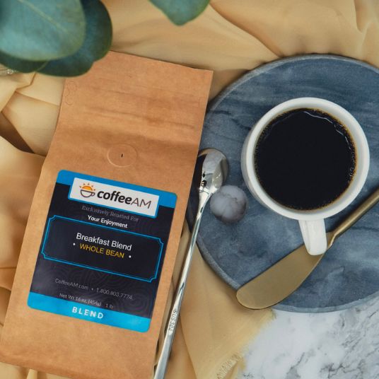 CoffeeAM coffee package with a cup of coffee on a blue coaster