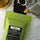 Green tea package with 'coffeeAM' label on a white surface with tea-making items.