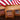 Three coffee packages with 'Coconut Cream' flavor label in front of an American flag background.