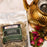 Package of Coffee AM Caribbean Green Tea with a gold teapot and tea leaves on a white background