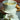 White teacup with tea and a tea bag on a saucer, with dried oranges in the background.