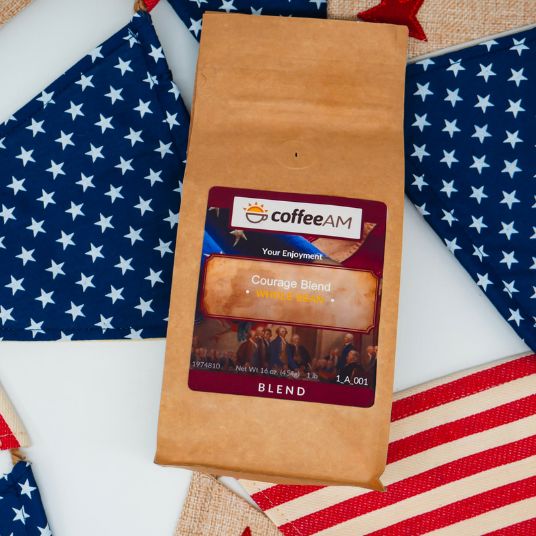 Coffee AM Courage Blend package on a table with American flags in the background