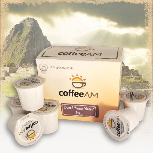 A box of CoffeeAM single serve coffee pods with a background featuring Machu Picchu. The box is labeled with 'Decaf Swiss Water Peru'.