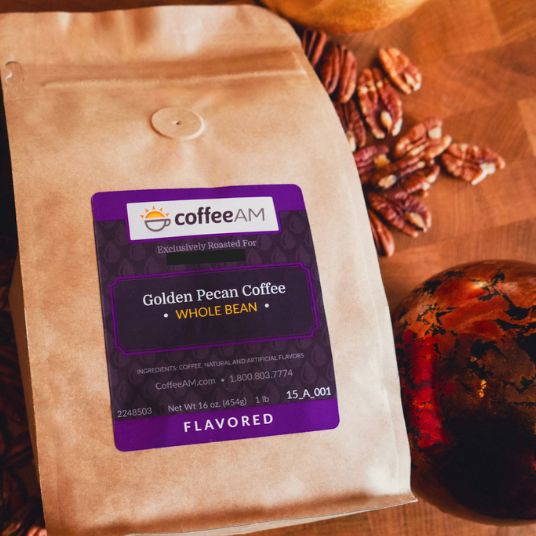 CoffeeAM Golden Pecan coffee package on a wooden surface with pecans.