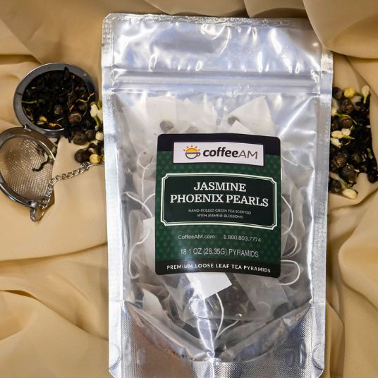 Package of Coffee AM Jasmine Phoenix Pearls tea on a beige fabric background