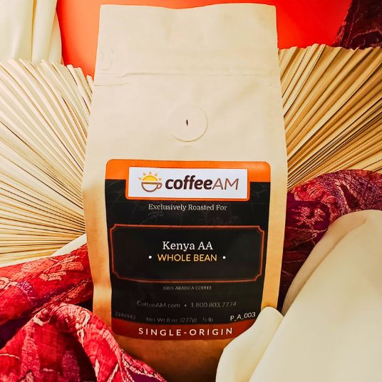 CoffeeAM Kenya AA whole bean coffee package on a decorative background