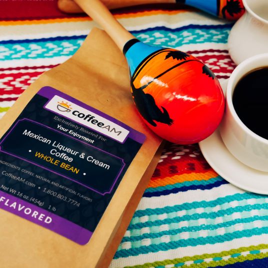 CoffeeAM Mexican Liqueur & Cream coffee package with a maraca and cup of coffee on a colorful fabric background