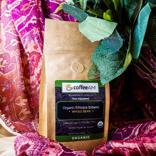 CoffeeAM organic Ethiopia Sidamo coffee bag on a colorful fabric background