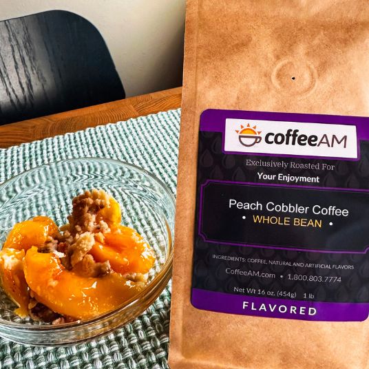 CoffeeAM Peach Cobbler coffee package next to a glass dish of peach cobbler on a table.