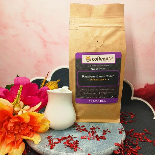 Coffee AM Raspberry Cream Coffee package with flowers and a pitcher on a decorative stand.