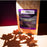 A stand-up kraft paper coffee bag labeled coffeeAM Vermont Maple Pecan Coffee, French Press, standing on a white surface with strong directional sunlight casting leaf-shaped shadows across the background.