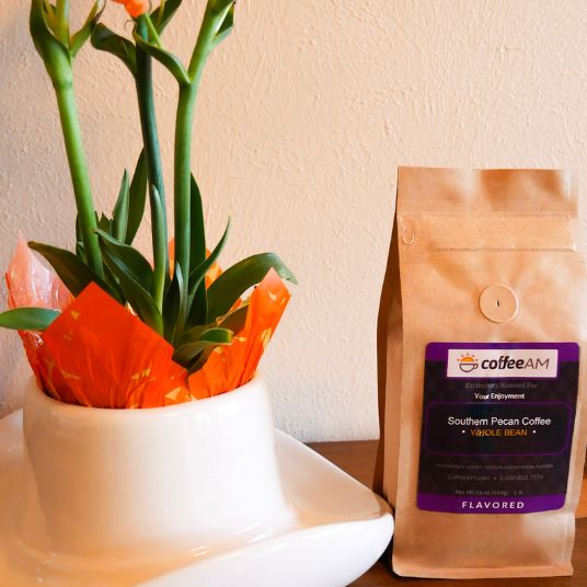 CoffeeAM coffee bag next to a potted plant on a table